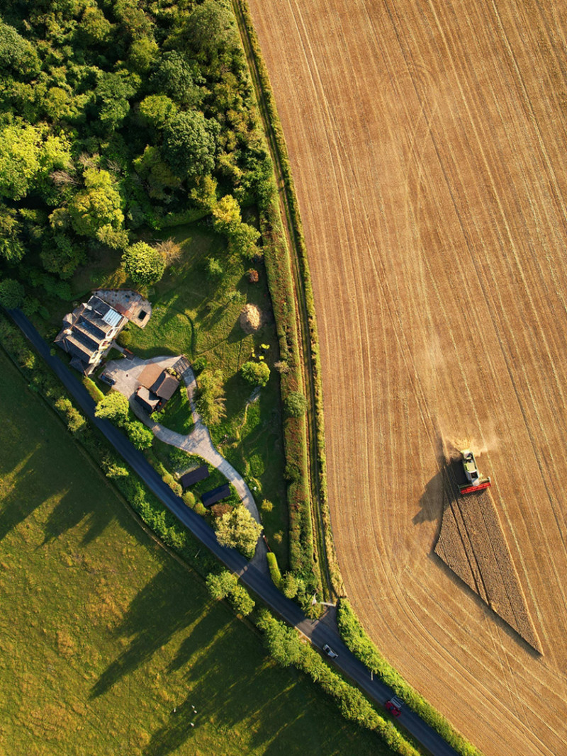 An aerial view of a tractor at work in a farm.
